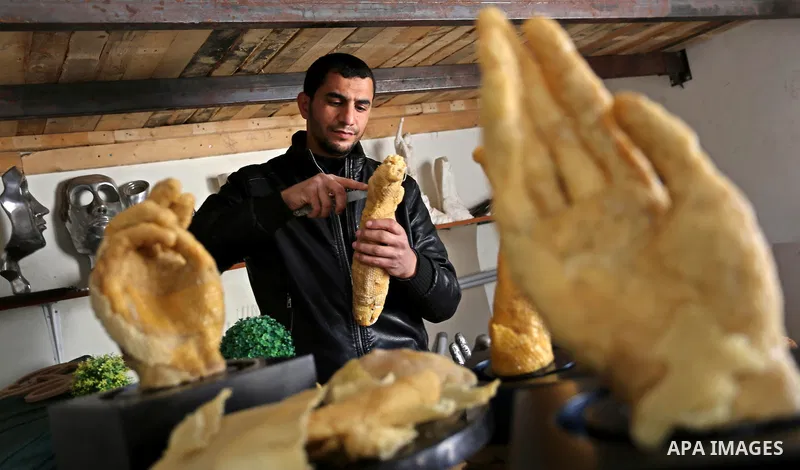 Palestinian artist, Mohammed Abu Hashish, 29, uses beeswax to produce models of human limb, at his workshop, in the al-Maghazi refugee camp, in the centre of the Gaza Strip, on February 27, 2017. Photo by Ashraf Amra