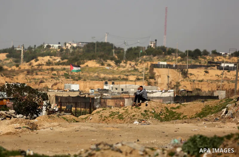 A Palestinian youth sists outside his house in Beit Lahia, near the border with Israel, in the northern Gaza Strip, on February 27, 2017. Photo by Ashraf Amra