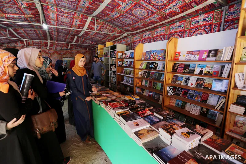 Palestinians browse through books on a stand at a book fair, in Gaza city on March 04, 2017. Photo by Ashraf Amra