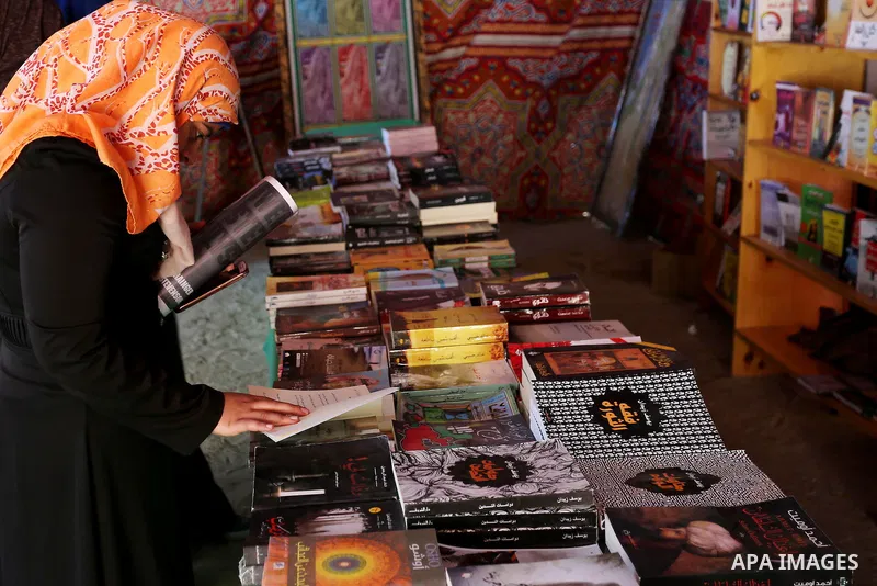 Palestinians browse through books on a stand at a book fair, in Gaza city on March 04, 2017. Photo by Ashraf Amra