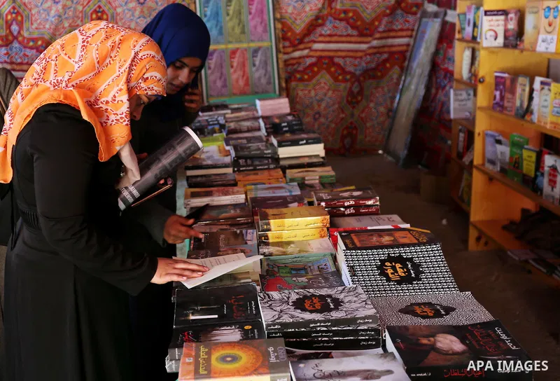 Palestinians browse through books on a stand at a book fair, in Gaza city on March 04, 2017. Photo by Ashraf Amra