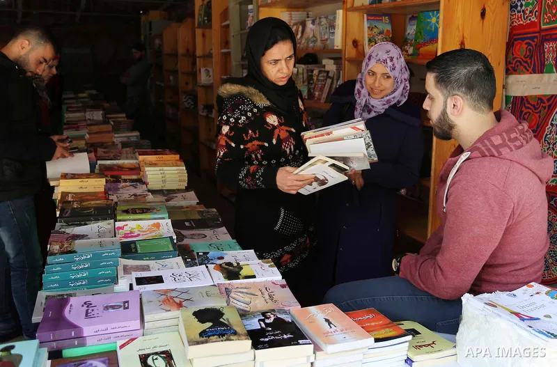 Palestinians browse through books on a stand at a book fair, in Gaza city on March 04, 2017. Photo by Ashraf Amra