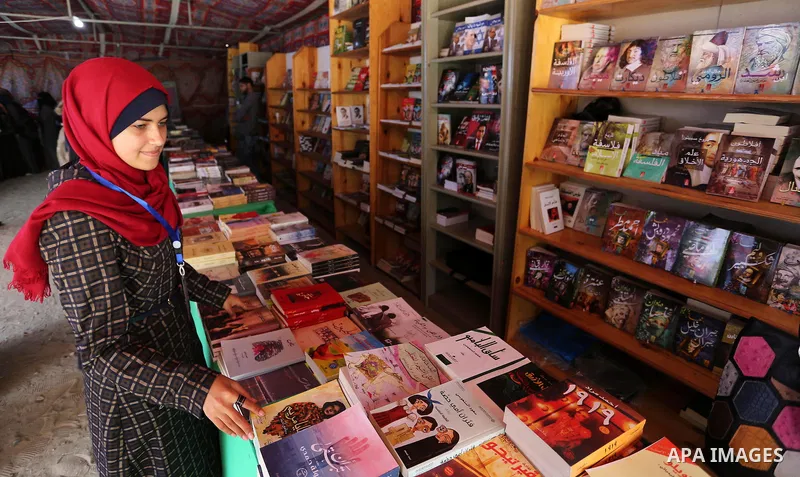 Palestinians browse through books on a stand at a book fair, in Gaza city on March 04, 2017. Photo by Ashraf Amra