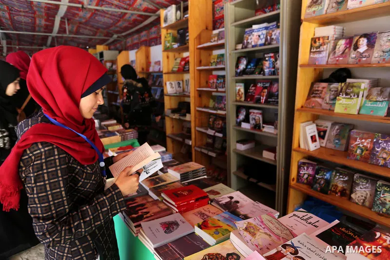 Palestinians browse through books on a stand at a book fair, in Gaza city on March 04, 2017. Photo by Ashraf Amra