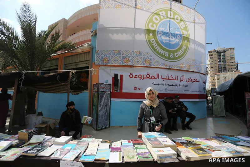 Palestinians browse through books on a stand at a book fair, in Gaza city on March 04, 2017. Photo by Ashraf Amra