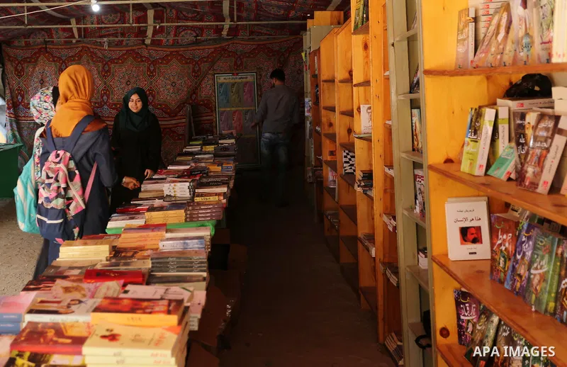 Palestinians browse through books on a stand at a book fair, in Gaza city on March 04, 2017. Photo by Ashraf Amra