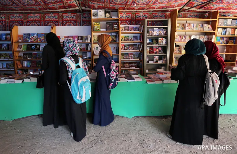 Palestinians browse through books on a stand at a book fair, in Gaza city on March 04, 2017. Photo by Ashraf Amra