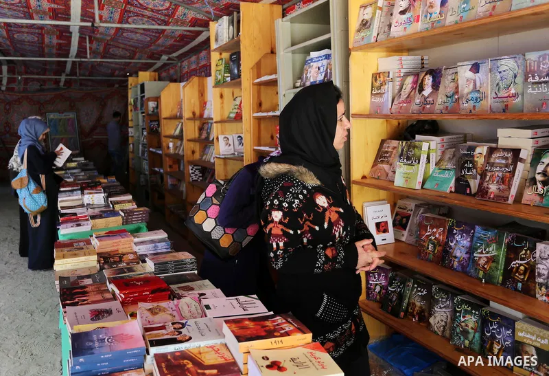 Palestinians browse through books on a stand at a book fair, in Gaza city on March 04, 2017. Photo by Ashraf Amra