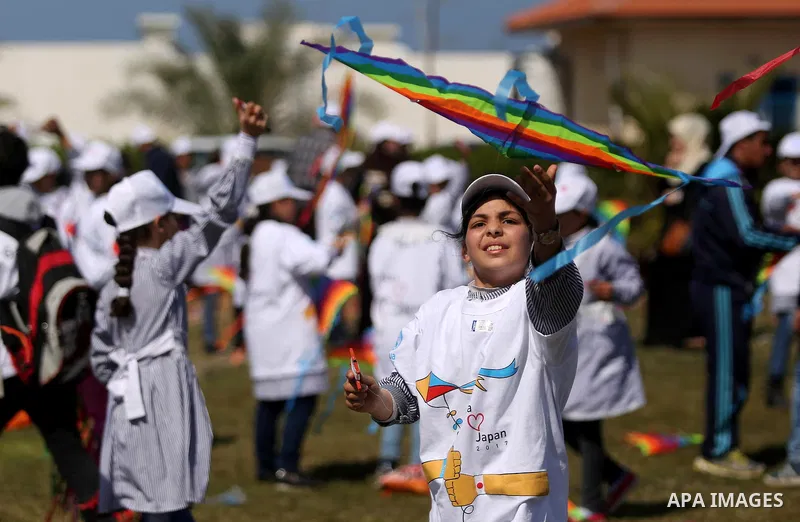Palestinian schoolgirls fly kites to show solidarity with the Japanese people during an event organised by the United Nations Relief and Works Agency (UNRWA) to mark the the sixth anniversary of the Tohoku earthquake and...