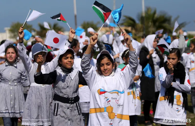 Palestinian schoolgirls fly kites to show solidarity with the Japanese people during an event organised by the United Nations Relief and Works Agency (UNRWA) to mark the the sixth anniversary of the Tohoku earthquake and...