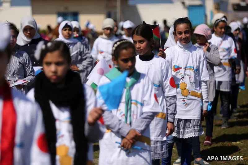 Palestinian schoolgirls fly kites to show solidarity with the Japanese people during an event organised by the United Nations Relief and Works Agency (UNRWA) to mark the the sixth anniversary of the Tohoku earthquake and...