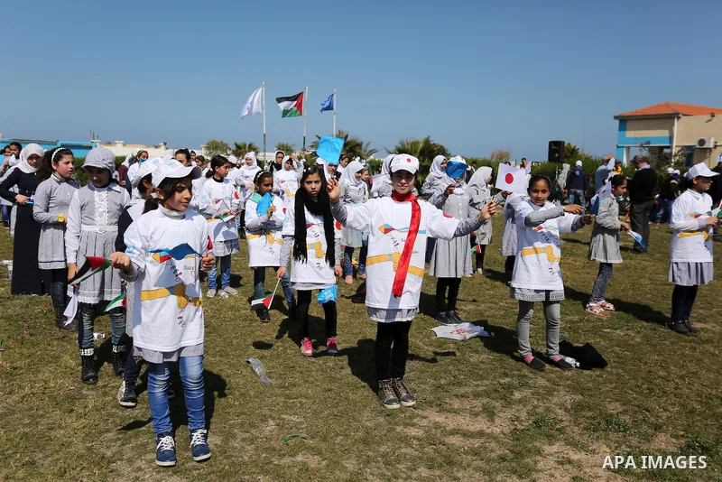 Palestinian schoolgirls fly kites to show solidarity with the Japanese people during an event organised by the United Nations Relief and Works Agency (UNRWA) to mark the the sixth anniversary of the Tohoku earthquake and...
