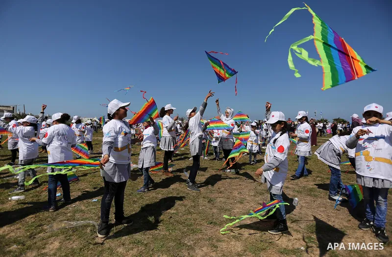 Palestinian schoolgirls fly kites to show solidarity with the Japanese people during an event organised by the United Nations Relief and Works Agency (UNRWA) to mark the the sixth anniversary of the Tohoku earthquake and...