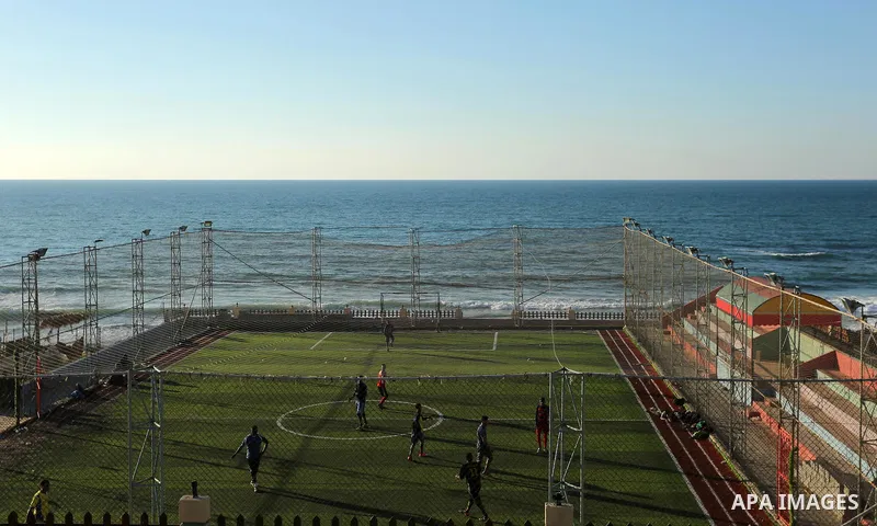 Palestinian youths play football at the artificial turf playground on the beach of Dair Al Balah, in the center of Gaza strip on March 05, 2017. Photo by Ashraf Amra