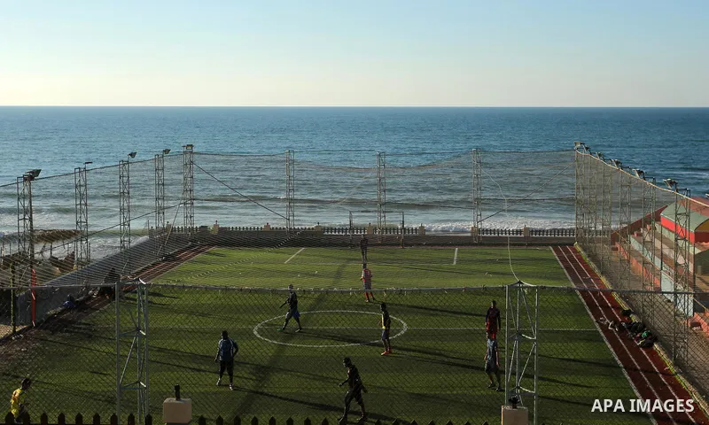 Palestinian youths play football at the artificial turf playground on the beach of Dair Al Balah, in the center of Gaza strip on March 05, 2017. Photo by Ashraf Amra