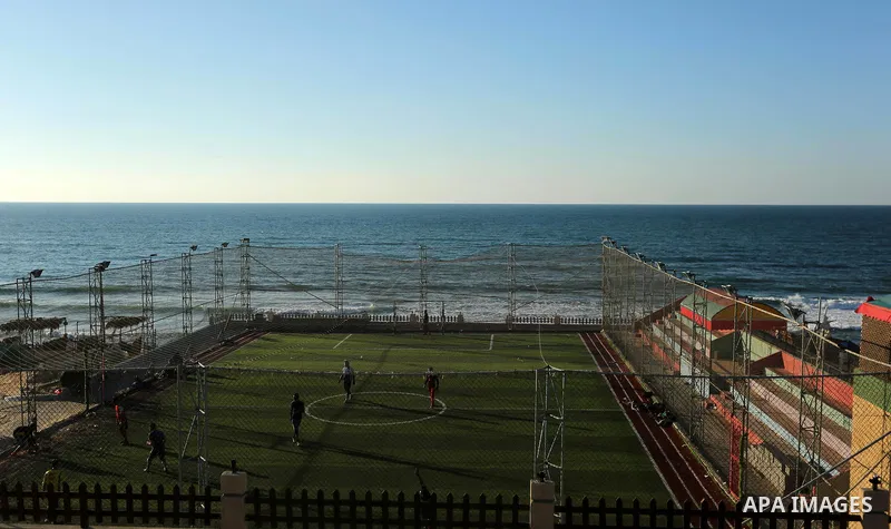 Palestinian youths play football at the artificial turf playground on the beach of Dair Al Balah, in the center of Gaza strip on March 05, 2017. Photo by Ashraf Amra