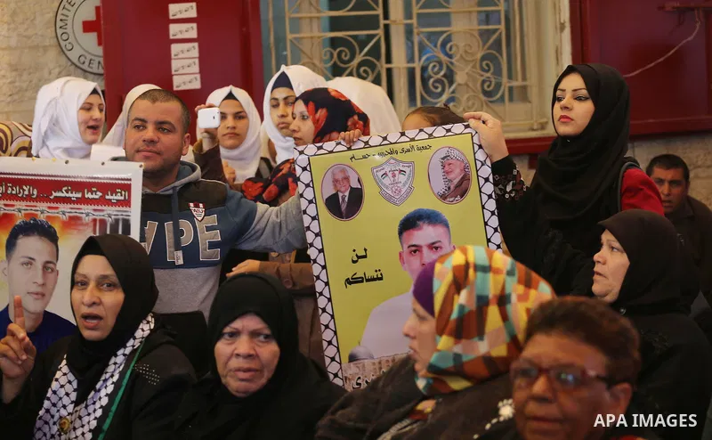 Palestinians hold placards during a protest to show solidarity with Palestinian prisoners held in Israeli Jails, in front of Red cross office in Gaza city, on March 6, 2017. Photo by Mohammed Asad