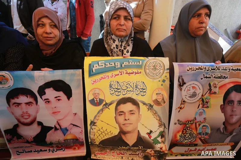 Palestinians hold placards during a protest to show solidarity with Palestinian prisoners held in Israeli Jails, in front of Red cross office in Gaza city, on March 6, 2017. Photo by Mohammed Asad