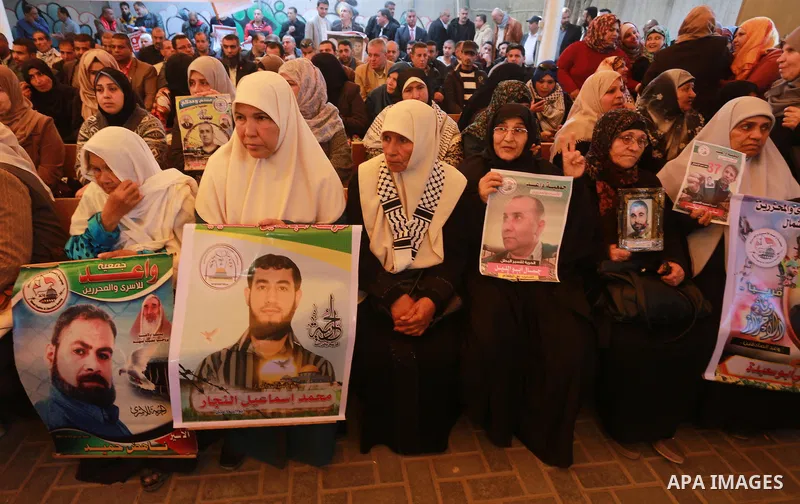Palestinians hold placards during a protest to show solidarity with Palestinian prisoners held in Israeli Jails, in front of Red cross office in Gaza city, on March 6, 2017. Photo by Mohammed Asad