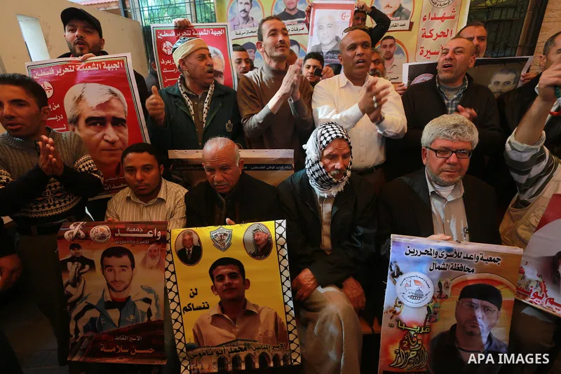 Palestinians hold placards during a protest to show solidarity with Palestinian prisoners held in Israeli Jails, in front of Red cross office in Gaza city, on March 6, 2017. Photo by Mohammed Asad