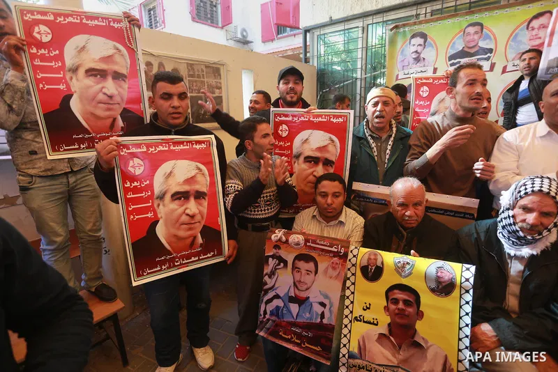 Palestinians hold placards during a protest to show solidarity with Palestinian prisoners held in Israeli Jails, in front of Red cross office in Gaza city, on March 6, 2017. Photo by Mohammed Asad