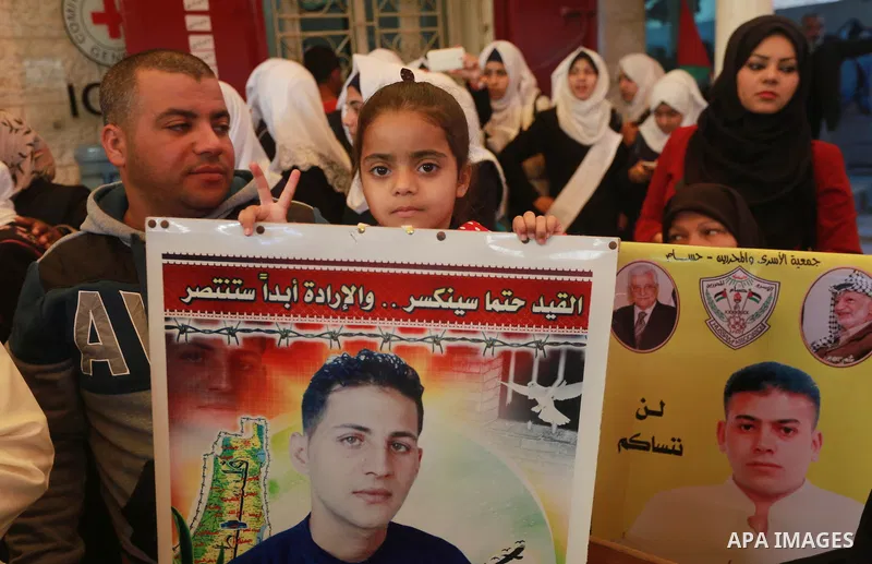 Palestinians hold placards during a protest to show solidarity with Palestinian prisoners held in Israeli Jails, in front of Red cross office in Gaza city, on March 6, 2017. Photo by Mohammed Asad