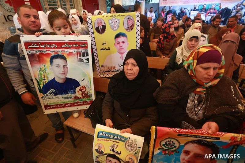 Palestinians hold placards during a protest to show solidarity with Palestinian prisoners held in Israeli Jails, in front of Red cross office in Gaza city, on March 6, 2017. Photo by Mohammed Asad