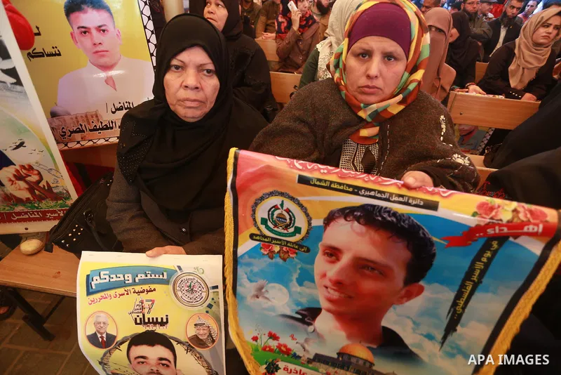 Palestinians hold placards during a protest to show solidarity with Palestinian prisoners held in Israeli Jails, in front of Red cross office in Gaza city, on March 6, 2017. Photo by Mohammed Asad
