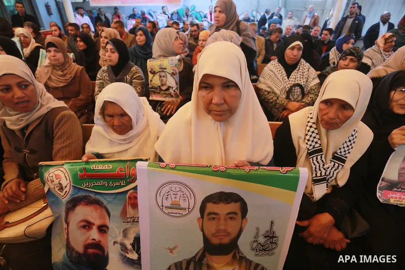 Palestinians hold placards during a protest to show solidarity with Palestinian prisoners held in Israeli Jails, in front of Red cross office in Gaza city, on March 6, 2017. Photo by Mohammed Asad