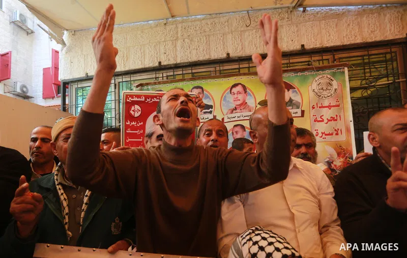 Palestinians hold placards during a protest to show solidarity with Palestinian prisoners held in Israeli Jails, in front of Red cross office in Gaza city, on March 6, 2017. Photo by Mohammed Asad