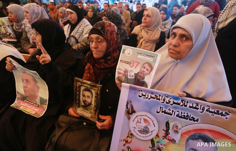 Palestinians hold placards during a protest to show solidarity with Palestinian prisoners held in Israeli Jails, in front of Red cross office in Gaza city, on March 6, 2017. Photo by Mohammed Asad
