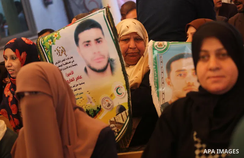 Palestinians hold placards during a protest to show solidarity with Palestinian prisoners held in Israeli Jails, in front of Red cross office in Gaza city, on March 6, 2017. Photo by Mohammed Asad