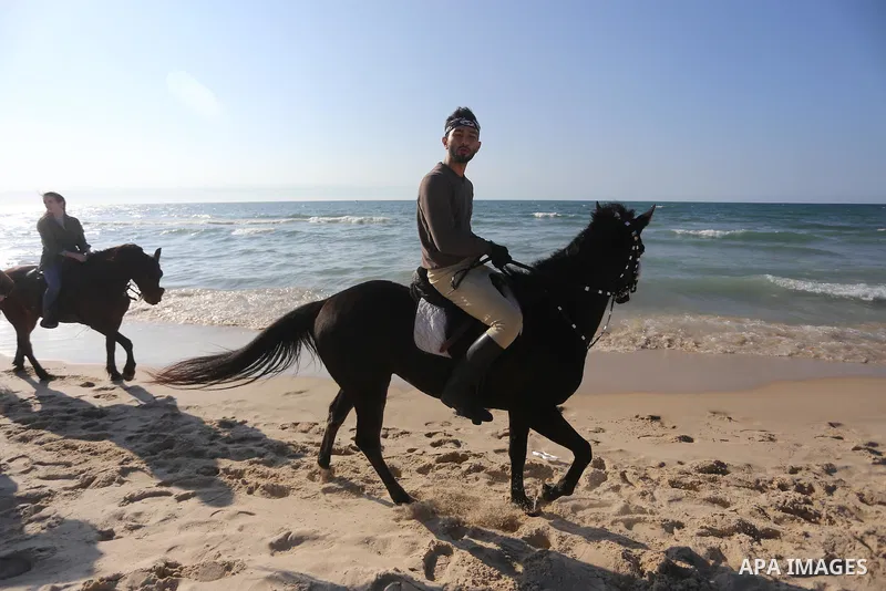 Palestinians rides their horse as they enjoy in the Mediterranean Sea off the coast of Gaza City on March 6, 2017. Photo by Mohammed Asad
