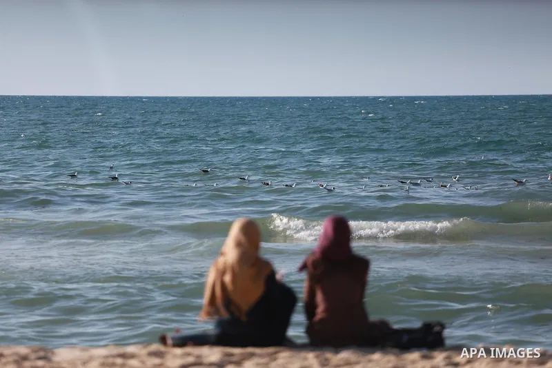 Palestinians sit as they enjoy in the Mediterranean Sea off the coast of Gaza City on March 6, 2017. Photo by Mohammed Asad