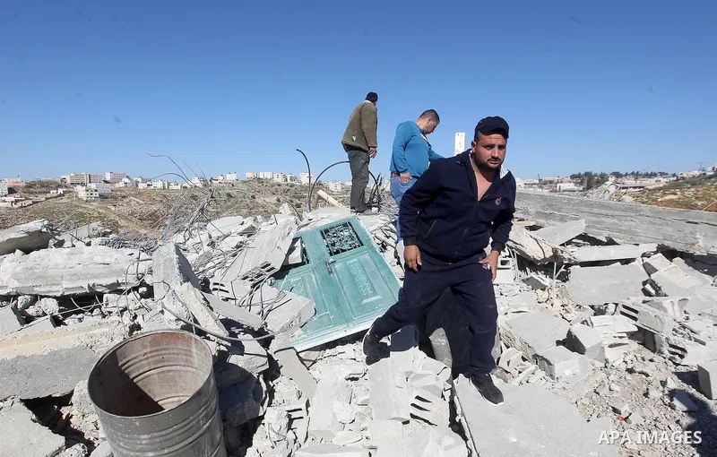 Palestinians remove belongings from rubble of a house after it was demolished by the Israeli army as it did not have an Israeli-issued construction permit, in the West Bank city of Hebron March 6, 2017. Photo by Wisam Ha...