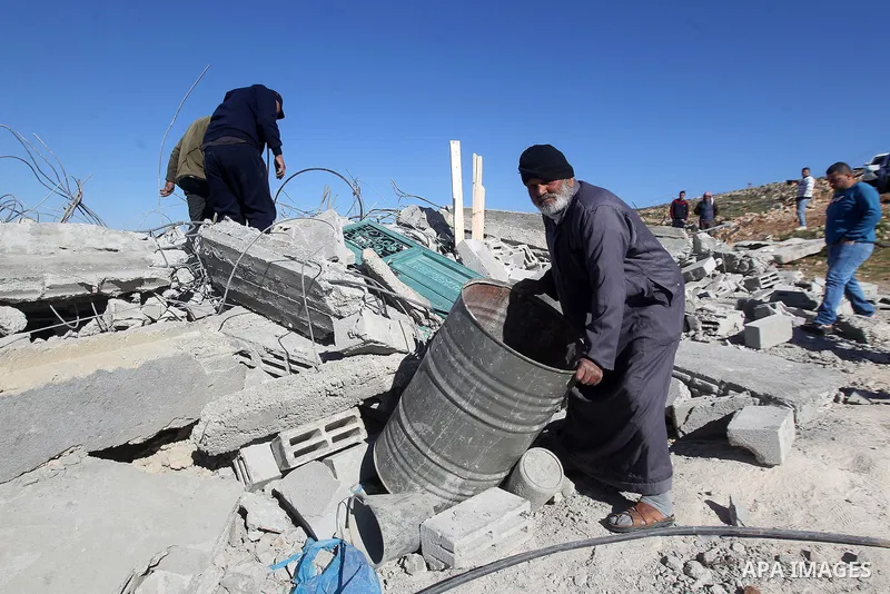 Palestinians remove belongings from rubble of a house after it was demolished by the Israeli army as it did not have an Israeli-issued construction permit, in the West Bank city of Hebron March 6, 2017. Photo by Wisam Ha...