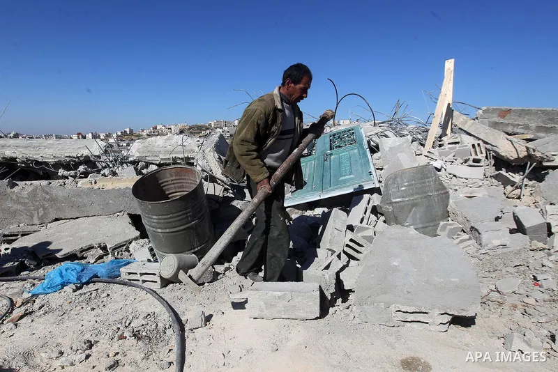 A Palestinian man looks for his belongings amongst the rubble of her house after it was demolished by the Israeli army as it did not have an Israeli-issued construction permit, in the West Bank city of Hebron March 6, 20...