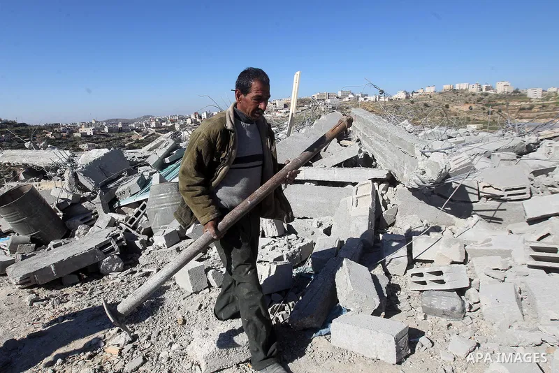 A Palestinian man looks for his belongings amongst the rubble of her house after it was demolished by the Israeli army as it did not have an Israeli-issued construction permit, in the West Bank city of Hebron March 6, 20...