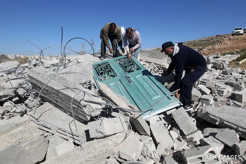 Palestinians remove belongings from rubble of a house after it was demolished by the Israeli army as it did not have an Israeli-issued construction permit, in the West Bank city of Hebron March 6, 2017. Photo by Wisam Ha...