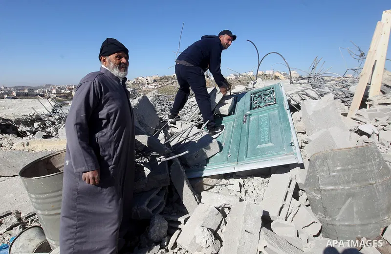 Palestinians remove belongings from rubble of a house after it was demolished by the Israeli army as it did not have an Israeli-issued construction permit, in the West Bank city of Hebron March 6, 2017. Photo by Wisam Ha...