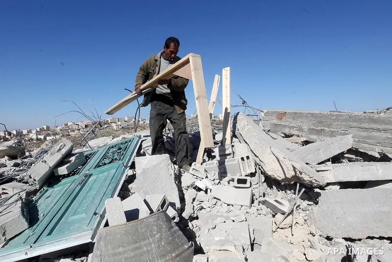 A Palestinian man looks for his belongings amongst the rubble of her house after it was demolished by the Israeli army as it did not have an Israeli-issued construction permit, in the West Bank city of Hebron March 6, 20...