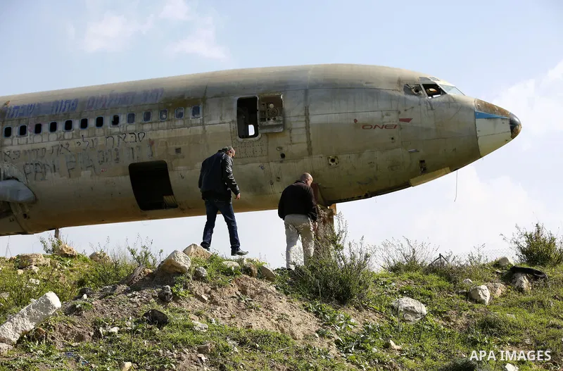 Palestinian taxi vans walk near a retired Boeing airplane once belonging to an Israeli airline has standing in an empty ground in the west bank city of Nablus, on March 7, 2017. Photo by Wisam Hashlamoun