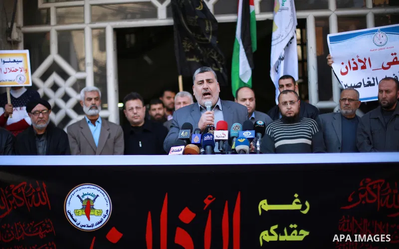 Palestinian supporters of the Islamic Jihad Movement hold banners during a protest against a controversial Israeli bill to limit the volume of calls to prayer at mosques in the occupied Jerusalem, in Gaza city on March 9...