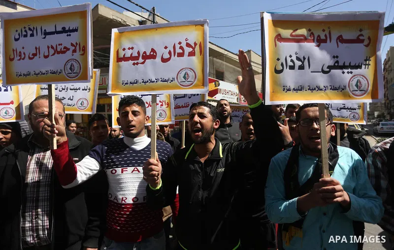 Palestinian supporters of the Islamic Jihad Movement hold banners during a protest against a controversial Israeli bill to limit the volume of calls to prayer at mosques in the occupied Jerusalem, in Gaza city on March 9...