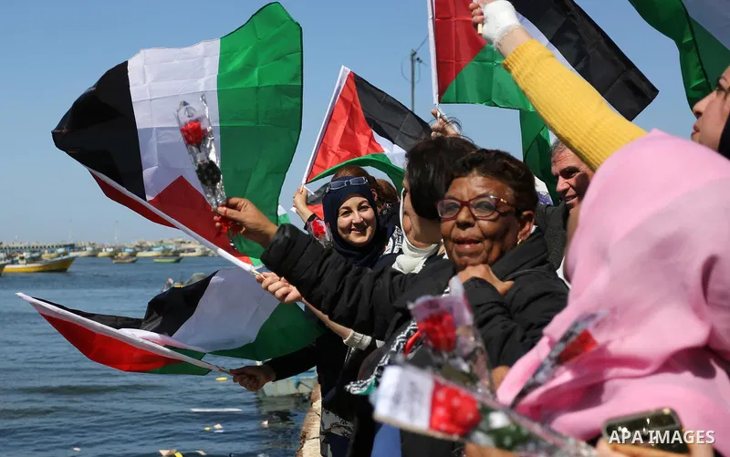 Palestinian women throw letters and flowers during a demonstration marking International Women's Day, in Gaza City on March 9, 2017. Photo by Ashraf Amra