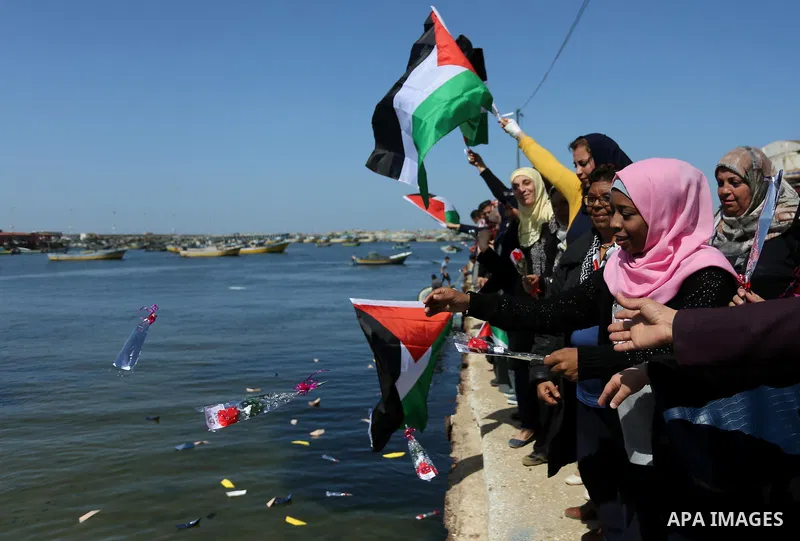 Palestinian women throw letters and flowers during a demonstration marking International Women's Day, in Gaza City on March 9, 2017. Photo by Ashraf Amra