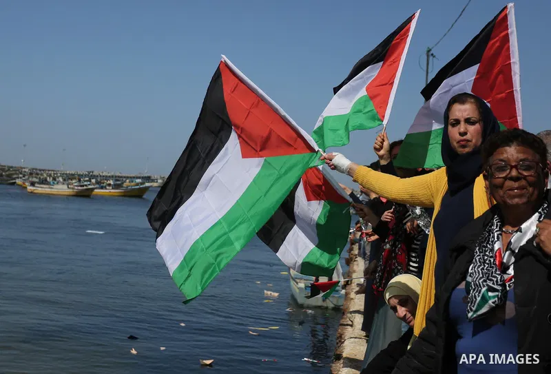 Palestinian women throw letters and flowers during a demonstration marking International Women's Day, in Gaza City on March 9, 2017. Photo by Ashraf Amra