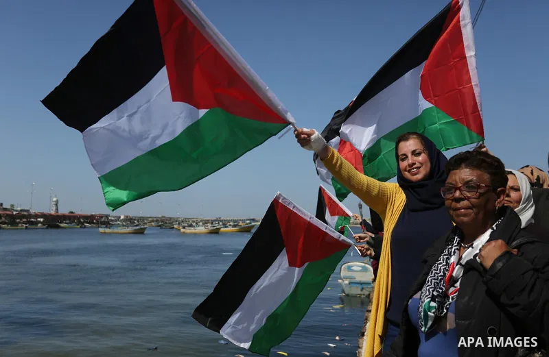 Palestinian women throw letters and flowers during a demonstration marking International Women's Day, in Gaza City on March 9, 2017. Photo by Ashraf Amra
