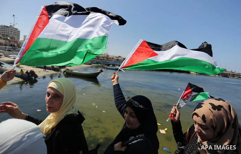 Palestinian women throw letters and flowers during a demonstration marking International Women's Day, in Gaza City on March 9, 2017. Photo by Ashraf Amra
