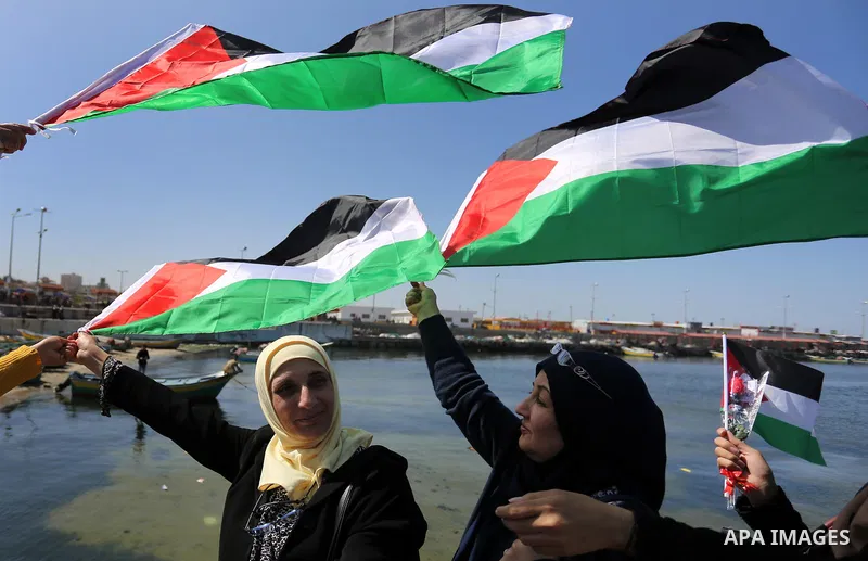 Palestinian women throw letters and flowers during a demonstration marking International Women's Day, in Gaza City on March 9, 2017. Photo by Ashraf Amra